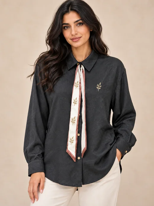 Women's long-sleeved button-through blouse in charcoal jacquard with a scarf collar, over-hip length, worn with cream trousers